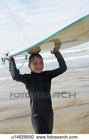 Young boy with surf board on his head View Large Photo Image Stock Image - Young boy with surf board on his head. Fotosearch