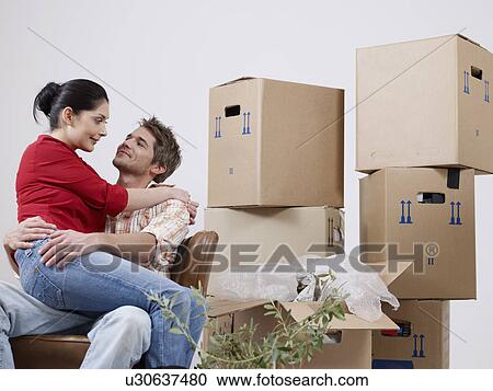Young couple between packing boxes View Large Photo Image Stock Image - Young couple between packing boxes. Fotosearch