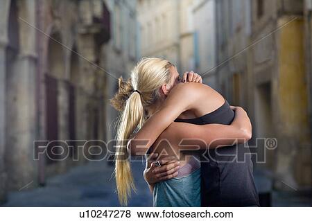 Stock Photo - Young couple hug in sunset street. Fotosearch