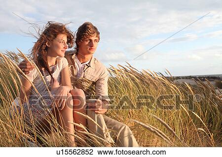 Young couple in the dunes at sunset View Large Photo Image Stock Image - Young couple in the dunes at sunset. Fotosearch