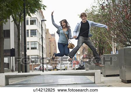 Young couple jumping in street View Large Photo Image Stock Photography - Young couple jumping in street. Fotosearch