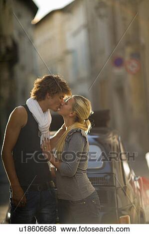Stock Photo - Young couple kiss in sunset street. Fotosearch
