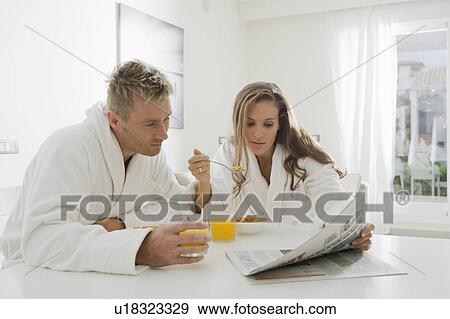 Young couple reading paper at breakfast View Large Photo Image Stock Photo - Young couple reading paper at breakfast. Fotosearch