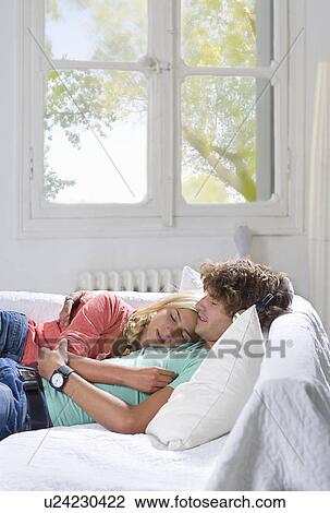 Young couple sleep on couch at home View Large Photo Image Stock Image - Young couple sleep on couch at home. Fotosearch