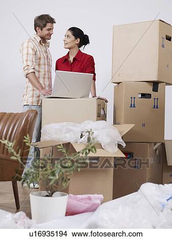 Young couple with boxes and laptop View Large Photo Image Picture - Young couple with boxes and laptop. Fotosearch