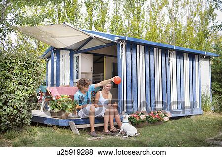 Young cple play ball with dog at cabin View Large Photo Image Stock Photo - Young cple play ball with dog at cabin. Fotosearch