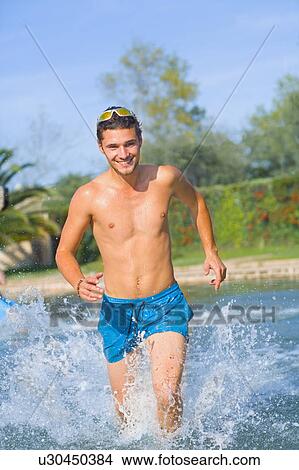 Young dynamic man runs in water View Large Photo Image Picture - Young dynamic man runs in water. Fotosearch