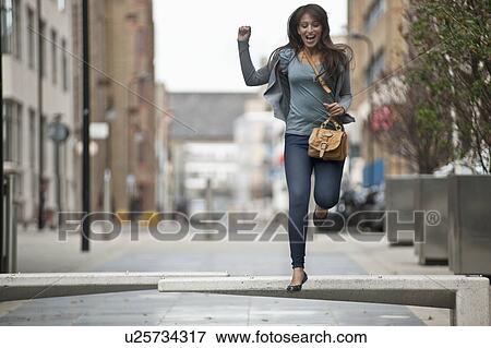 Stock Photo - Young female jumping in street. Fotosearch