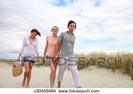 Picture - Young friends going for a beach picnic. Fotosearch