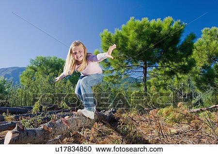 Young girl balancing/surfing on log View Large Photo Image Stock Image - Young girl balancing/surfing on log. Fotosearch