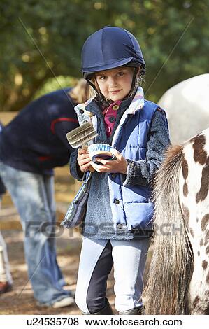 Stock Photo - Young girl grooming her pony. Fotosearch