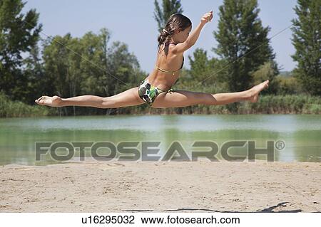 Young girl jumping the through the air View Large Photo Image Stock Image - Young girl jumping the through the air. Fotosearch