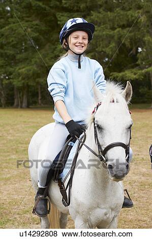 Young girl riding pony View Large Photo Image Stock Photo - Young girl riding pony. Fotosearch