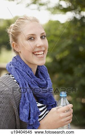 Stock Photography - Young girl smiling at camera with water. Fotosearch