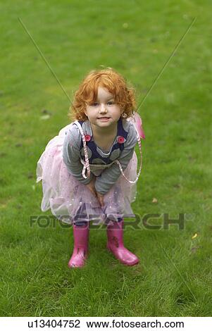 Stock Image - Young girl smiling in garden. Fotosearch