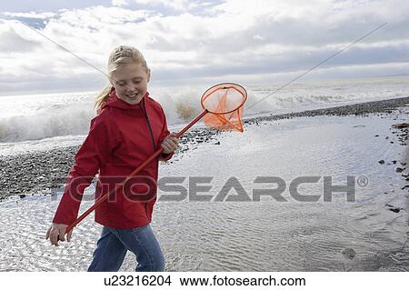 Young girl walking on beach with fishnet View Large Photo Image Picture - Young girl walking on beach with fishnet. Fotosearch