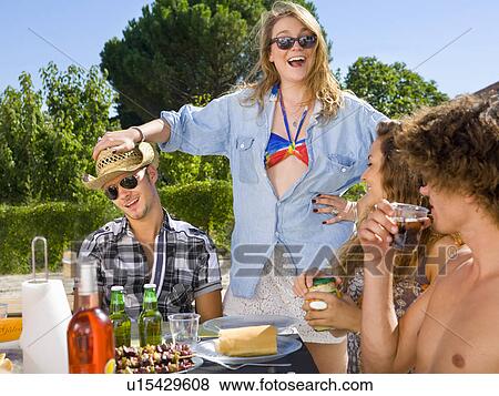 Stock Photo - Young group backyard BBQ laugh. Fotosearch