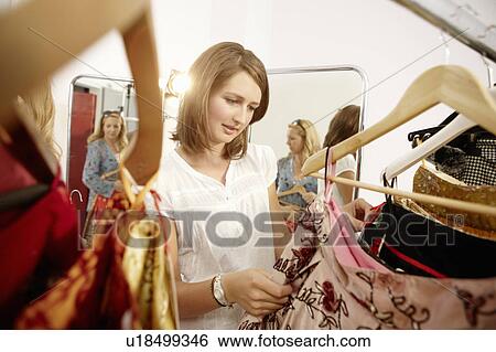 Young lady fascinated in fashion store View Large Photo Image Stock Photograph - Young lady fascinated in fashion store. Fotosearch