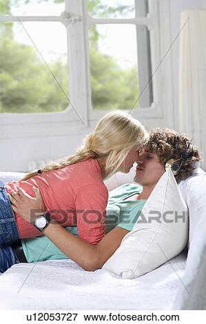 Young loving couple on couch at home View Large Photo Image Stock Photo - Young loving couple on couch at home. Fotosearch