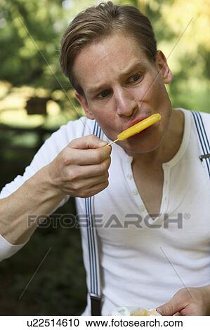 Stock Image - Young male eating ice cream. Fotosearch