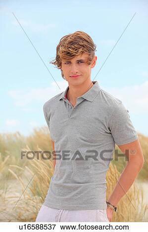 Stock Photo - Young man at a windswept beach. Fotosearch