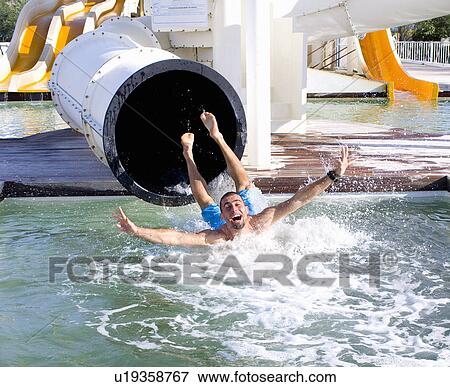Young man falls into pool from slide View Large Photo Image Stock Photo - Young man falls into pool from slide. Fotosearch