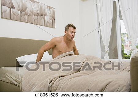 Young man getting up in the morning View Large Photo Image Stock Photograph - Young man getting up in the morning. Fotosearch