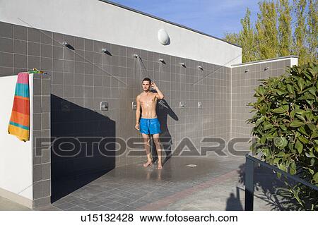 Stock Photo - Young man in outdoor shower with swimsui. Fotosearch