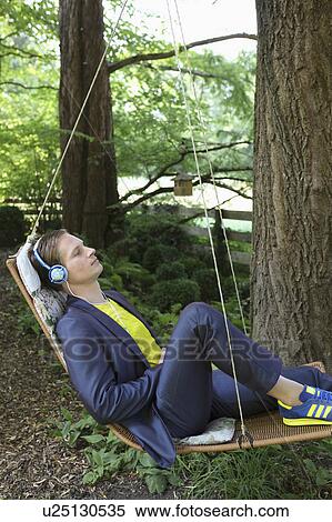 Young man relaxing in hammock View Large Photo Image Stock Photography - Young man relaxing in hammock. Fotosearch