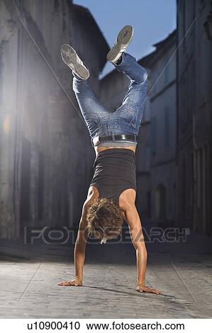 Young man walks on hands in street View Large Photo Image Stock Image - Young man walks on hands in street. Fotosearch