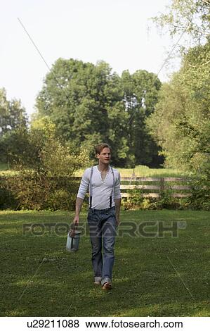 Young man with watering can View Large Photo Image Stock Photo - Young man with watering can. Fotosearch