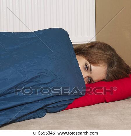 Stock Photography - Young woman coquetting next to box. Fotosearch