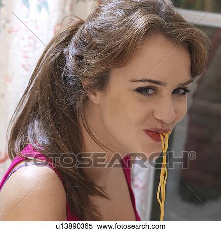 Stock Photography - Young woman eating pasta. Fotosearch