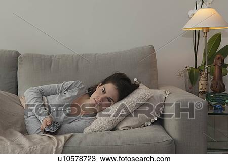 Young woman holding TV remote View Large Photo Image Stock Image - Young woman holding TV remote. Fotosearch