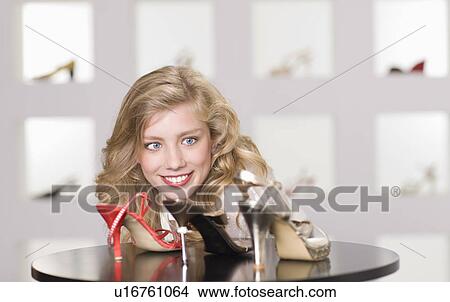 Picture - Young woman in shoe shop. Fotosearch