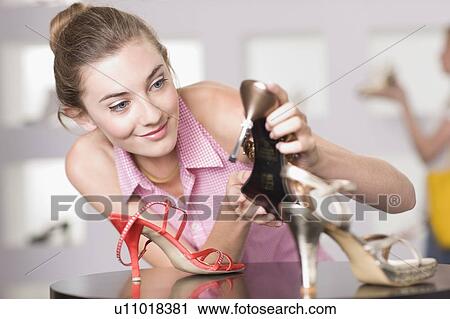 Stock Image - Young woman in shoe shop. Fotosearch