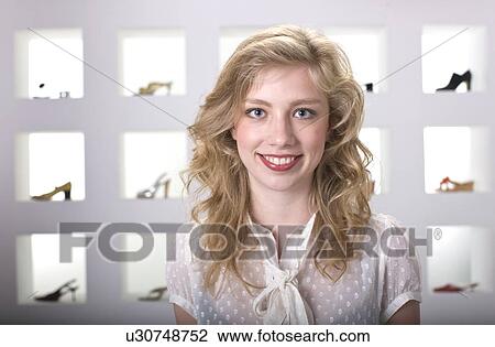 Stock Image - Young woman in shoe shop. Fotosearch