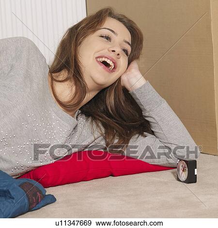 Young woman laughing next box View Large Photo Image Stock Photo - Young woman laughing next box. Fotosearch