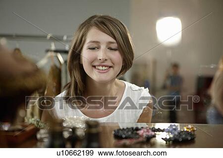 Stock Photo - Young woman looking at jewelry. Fotosearch