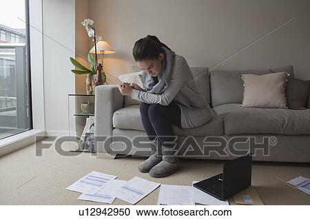 Stock Image - Young woman looking at paperwork. Fotosearch