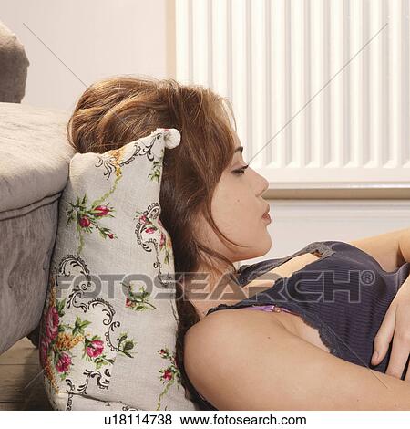 Young woman lying down head propped up View Large Photo Image Stock Photo - Young woman lying down head propped up. Fotosearch