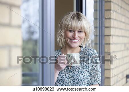 Stock Image - Young woman outside her apartment. Fotosearch