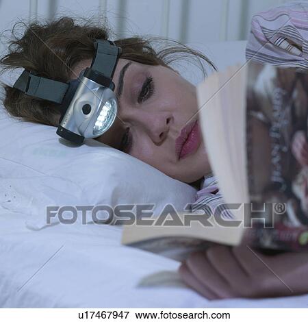 Young woman reading with head torch View Large Photo Image Stock Photo - Young woman reading with head torch. Fotosearch