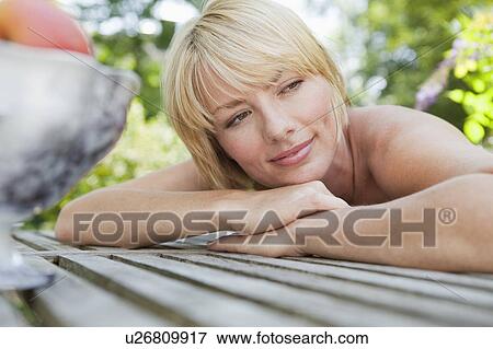 Young woman resting her head on table View Large Photo Image Stock Photo - Young woman resting her head on table. Fotosearch