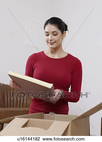 Young women unpacking books out of box View Large Photo Image Stock Image - Young women unpacking books out of box. Fotosearch