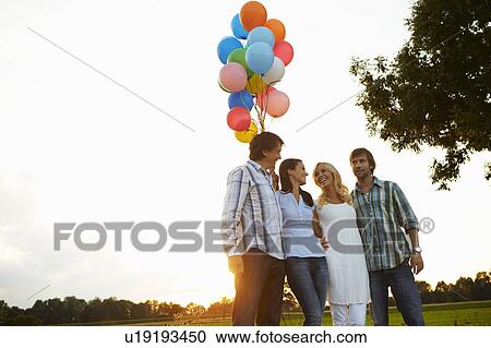 2 couples holding balloons at sunset View Large Photo Image Stock Image - 2 couples holding balloons at sunset. Fotosearch