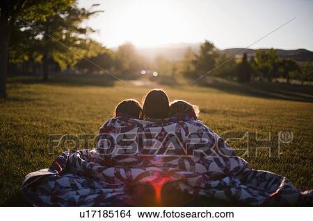 3 girls wrapped in blanket at sunset View Large Photo Image Picture - 3 girls wrapped in blanket at sunset. Fotosearch