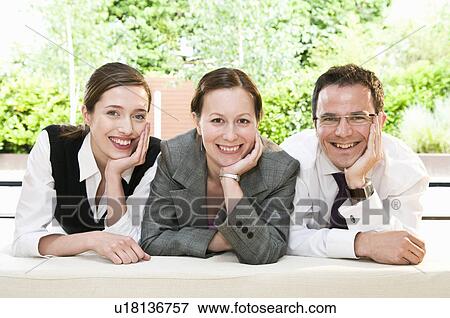 Stock Photo - 3 happy colleagues smile at camera. Fotosearch