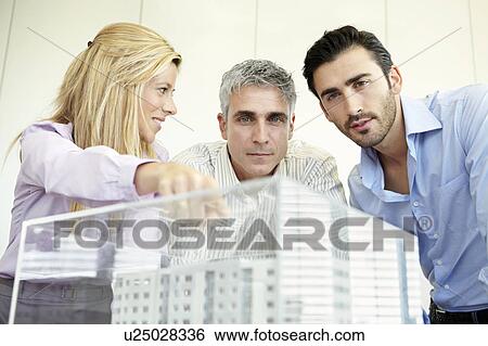 Stock Photograph - 3 people looking at architectural model. Fotosearch