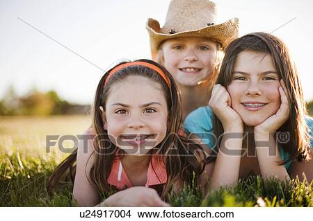 3 young girls laying in grass View Large Photo Image Picture - 3 young girls laying in grass. Fotosearch
